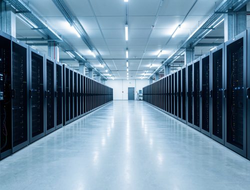 Centre de données moderne en Espagne montrant de longues rangées de baies informatiques avec confinement des allées chaudes et froides, dans une ambiance technique réaliste.